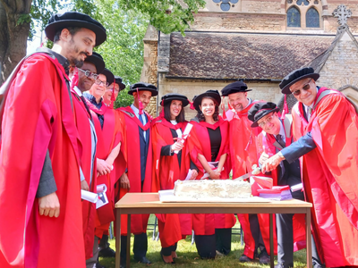 Graduands cutting the cake