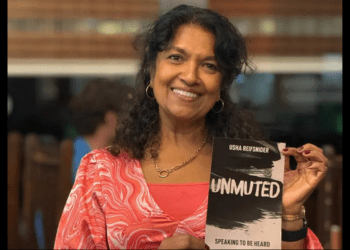 Usha Reifsnider holding copy of Unmuted